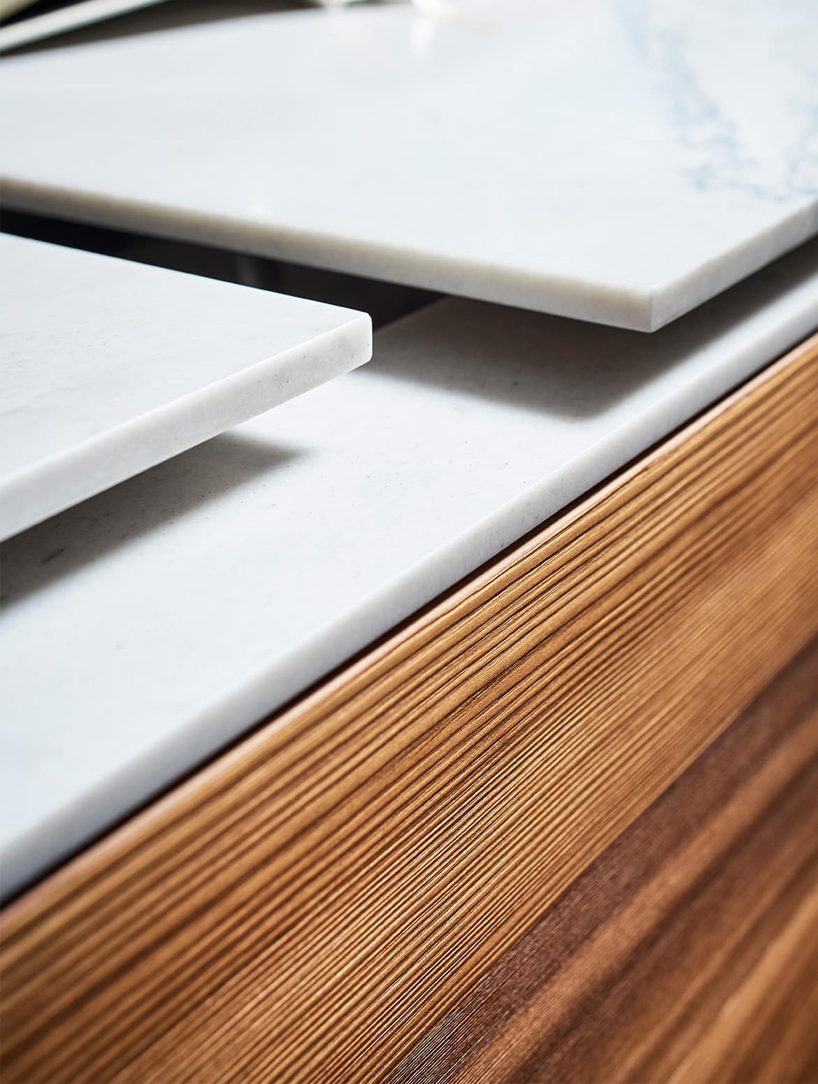 A modern kitchen with quartz-top islands. A close in of the central island with quartz worktop. The two raised ledges provide ease for chopping and draining around the sink. 