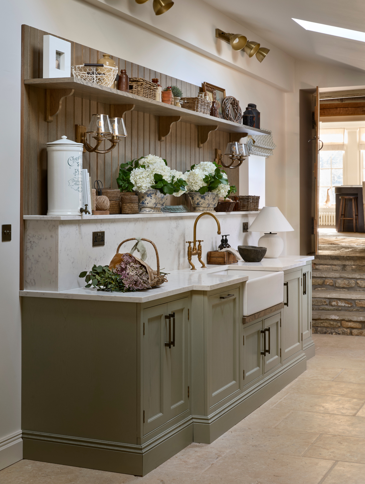 A traditional bootroom-cum-larder. The Belfast sink and worktop sits beneath two mounted cupboards. A antique brass Perin & Rowe Tap features. 