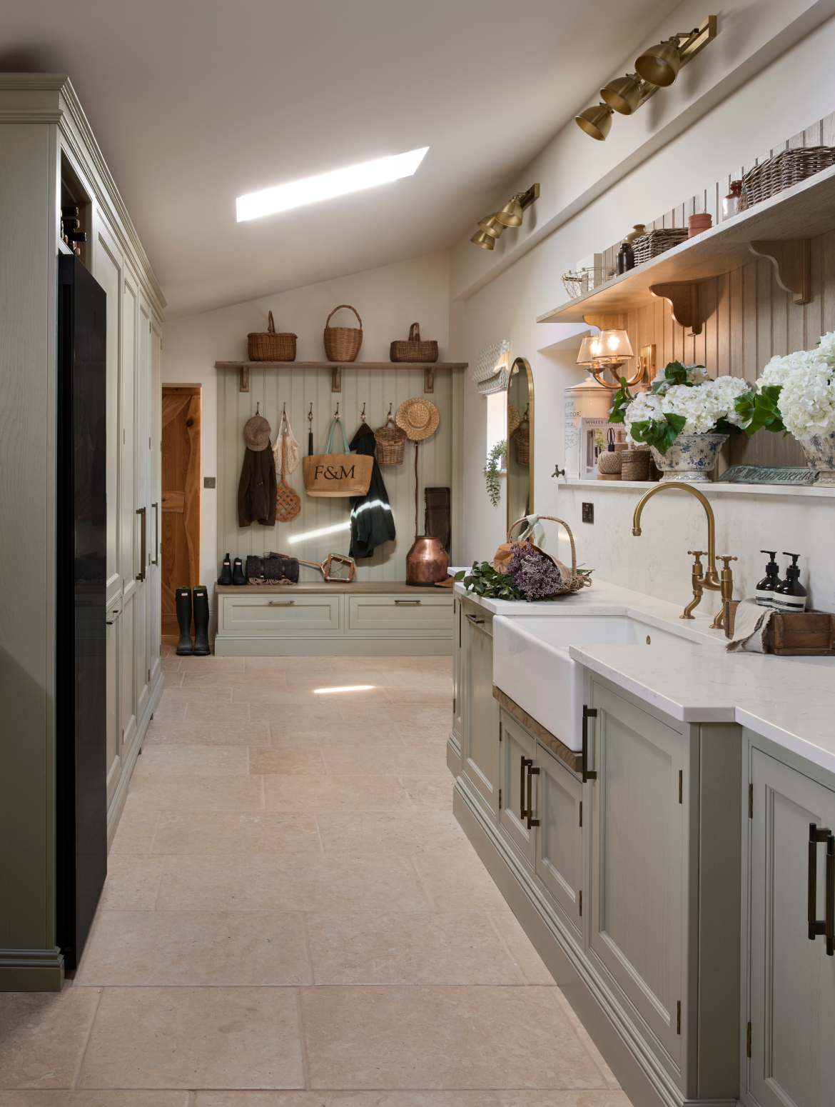 A traditional bootroom-cum-larder. The Belfast sink and worktop sits beneath two mounted cupboards. A antique brass Perin & Rowe Tap features. 